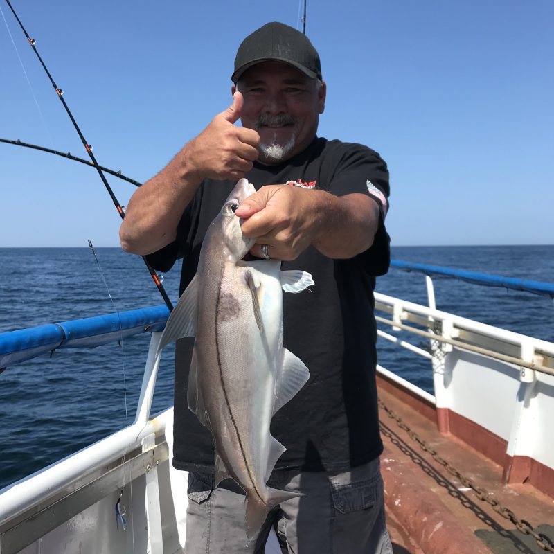 a man holding a fish in the water