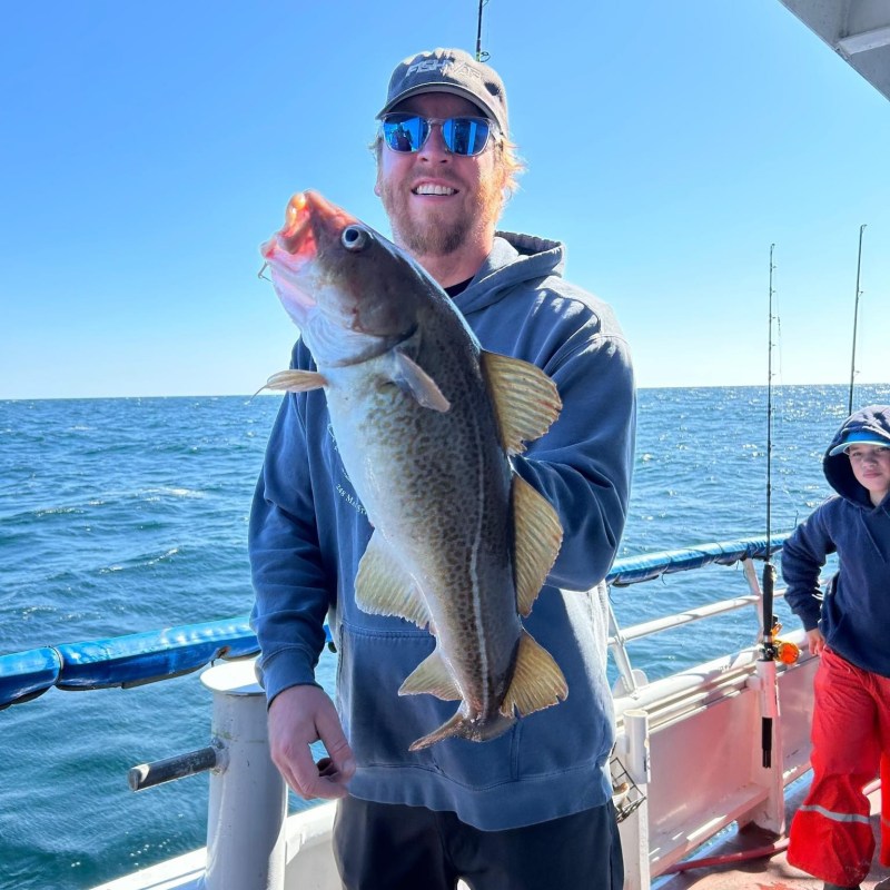 a person holding a fish on a boat in the water