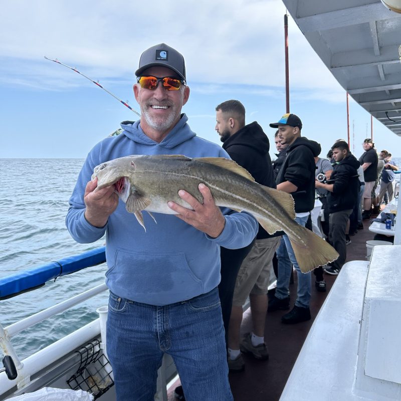 a person holding a fish on a boat