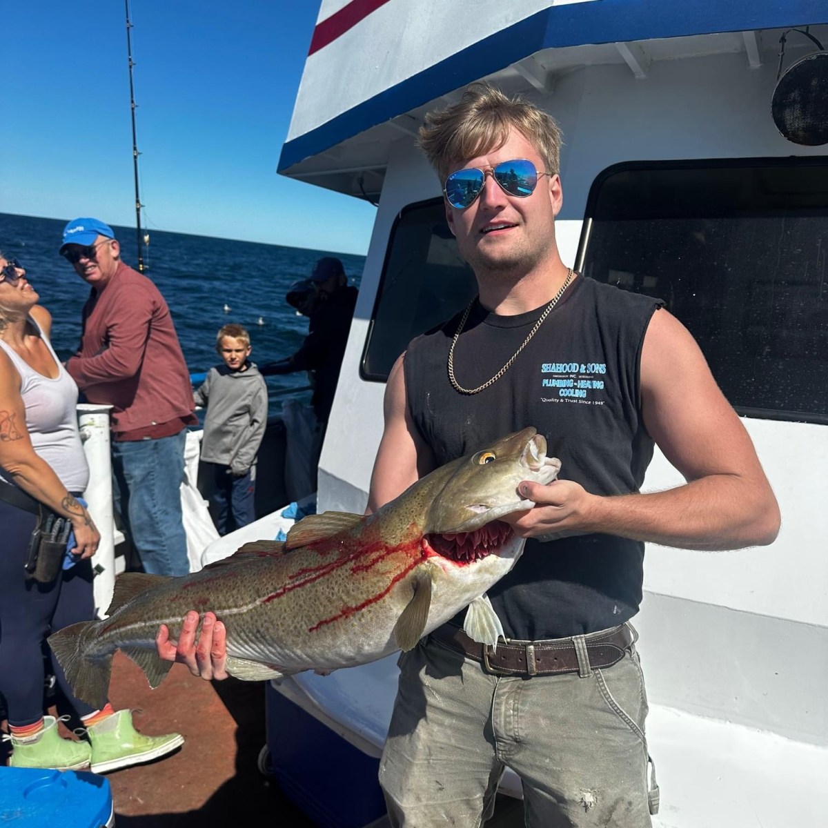 a person holding a fish on a boat