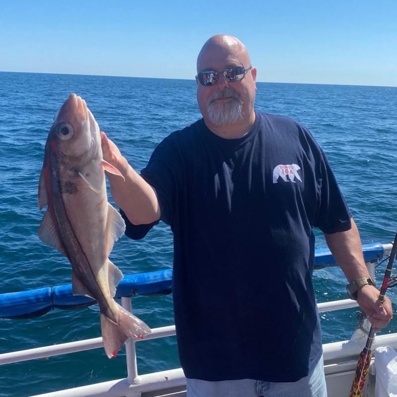 a man holding a fish in the water