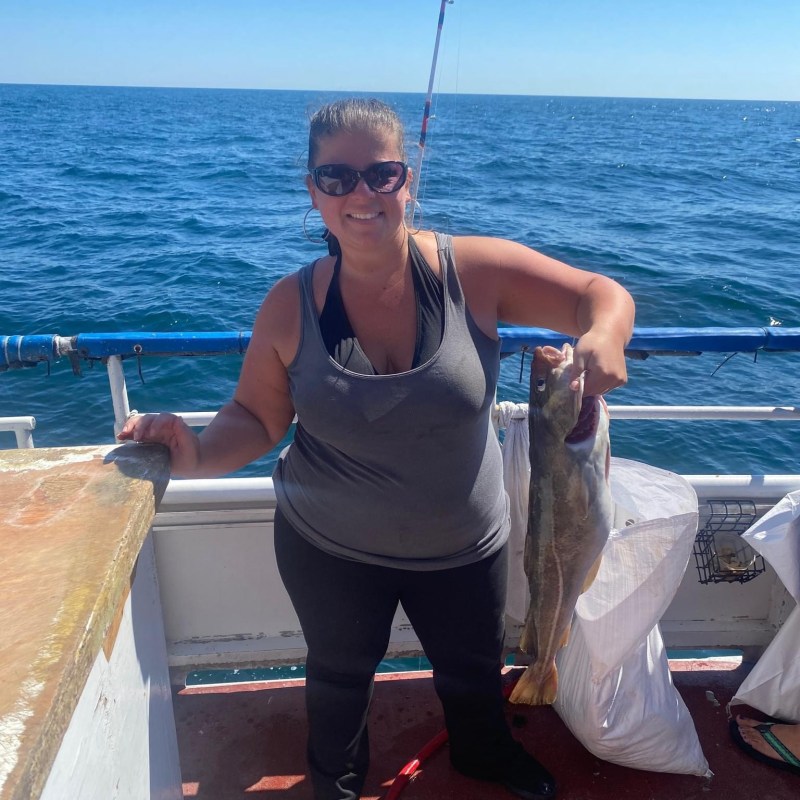 a woman standing next to a body of water