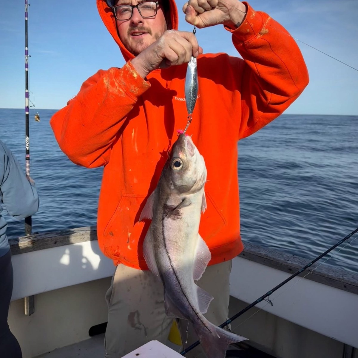 a person holding a fish on a boat in the water
