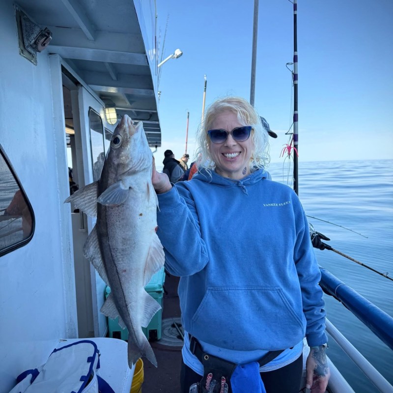 a person holding a fish posing for the camera