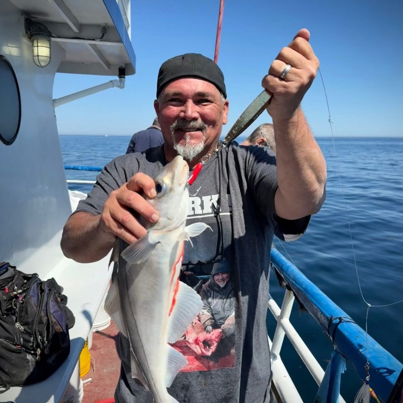 a man holding a fish on a boat