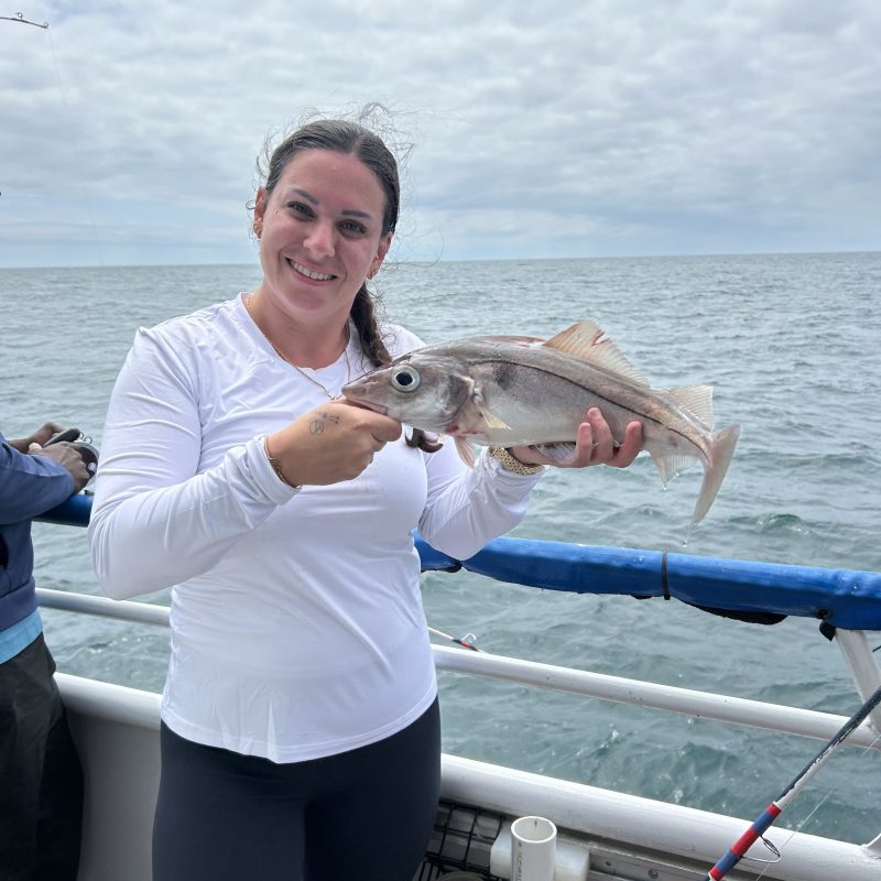 a woman standing next to a body of water