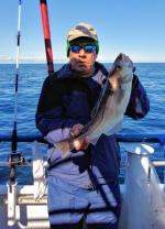 a person holding a fish on a boat in the water